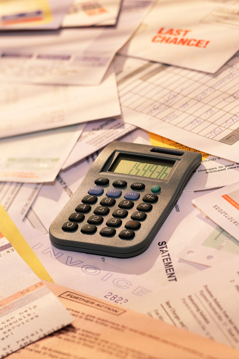 Calculator on pile of invoices